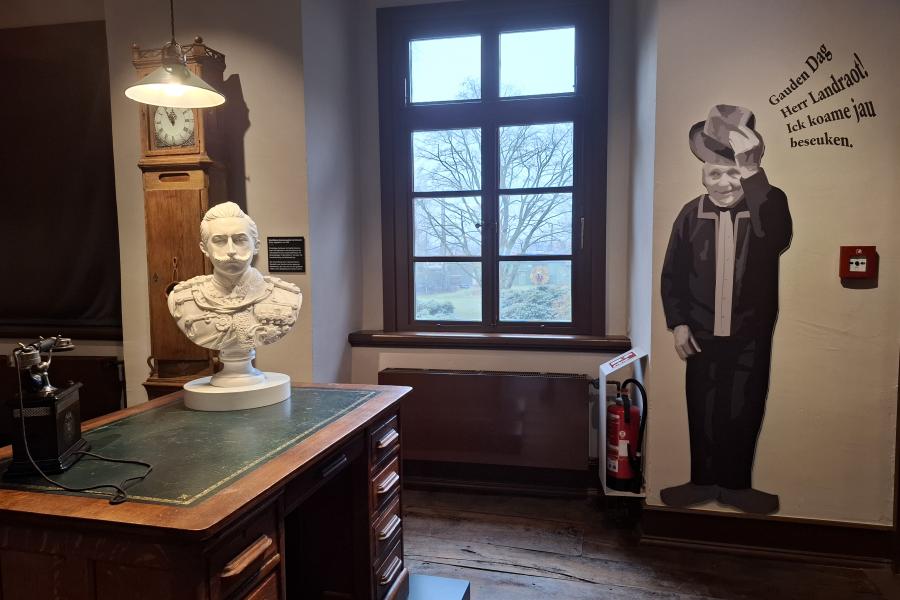Schreibstube des Landrats im Museum mit plattdeutschem Spruch an der Wand.